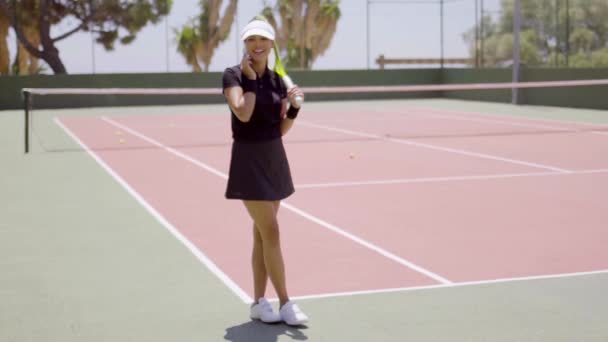 Mujer hablando por teléfono en la cancha de tenis — Vídeos de Stock