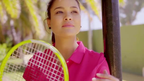 Женщина с теннисной ракеткой рядом с пальмой — стоковое видео