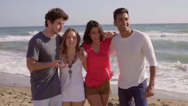 Parejas posando delante de la cámara en la playa — Vídeo de stock