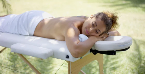 Vrouw vaststelling op massagetafel in spa — Stockfoto