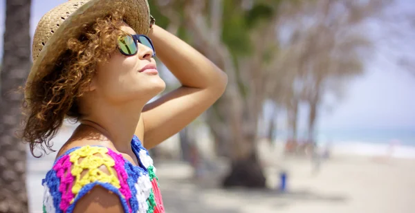 Mulher de óculos de sol e chapéu lá fora olhando para cima — Fotografia de Stock