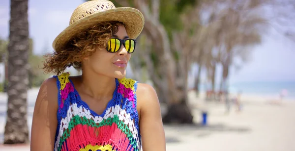 Femme souriante en lunettes de soleil et chapeau près de l'océan — Photo