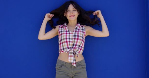Smiling happy young woman holding her hair — Stock Video
