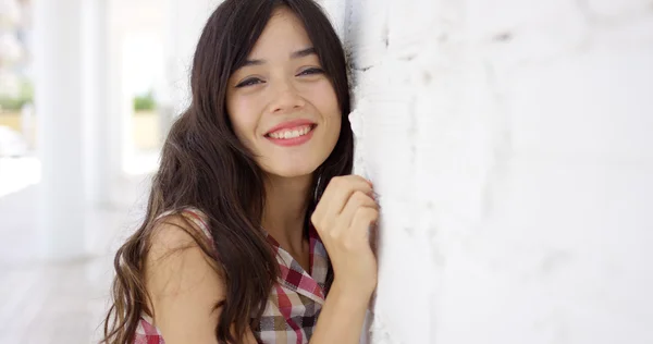 Jovem feliz apoiando-se em uma parede branca — Fotografia de Stock