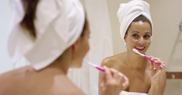 Mujer limpiando dientes con cepillo de dientes en el baño — Vídeo de stock