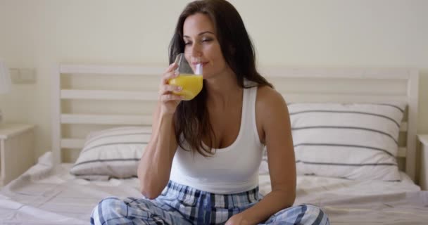 Jonge vrouw genieten van een glas sinaasappelsap — Stockvideo
