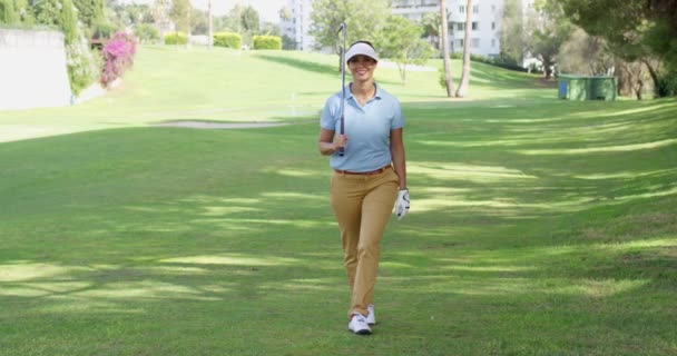 Lachende vriendelijke vrouw golfer lopen op een cursus — Stockvideo