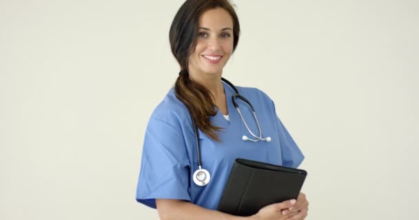 Woman in scrubs holds black portfolio — 图库视频影像