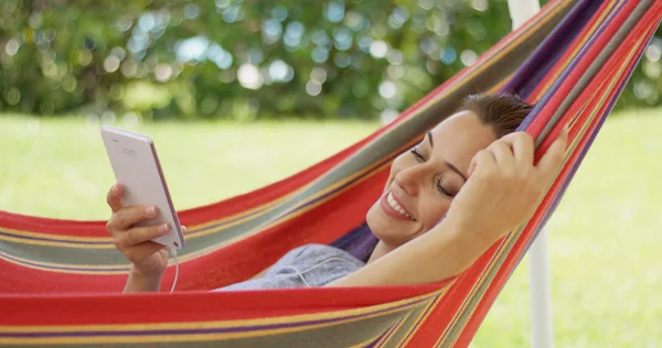 Woman listening to music in hammock — Stock Photo, Image