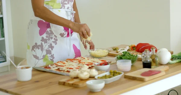 Женщина готовит пиццу на кухне — стоковое фото