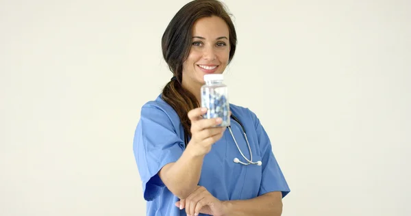 Läkare i scrubs innehar flaska — Stockfoto