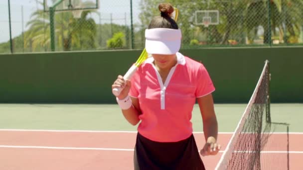 Женщина с теннисным мячом и ракеткой на корте — стоковое видео