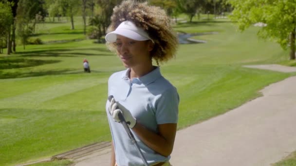 Vrouw poseren met golfclub in handen — Stockvideo