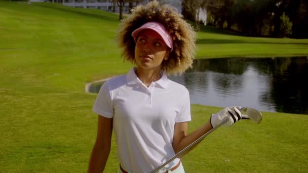Женщина позирует с клюшкой для гольфа в руках — стоковое видео