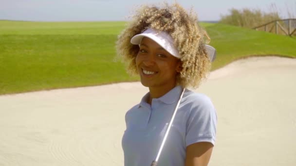 Женщина позирует с клюшкой для гольфа в руках — стоковое видео