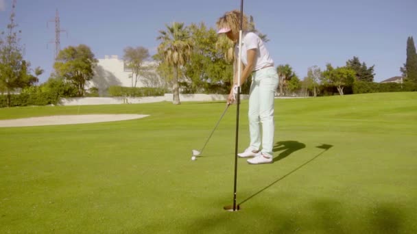 Женщина играет в гольф — стоковое видео