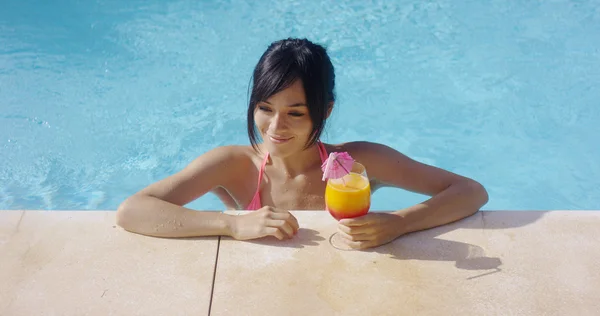 Mujer en piscina con cóctel tropical — Foto de Stock