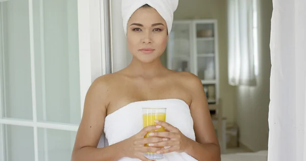 Woman wrapped in towel looking outside — Stock Photo, Image