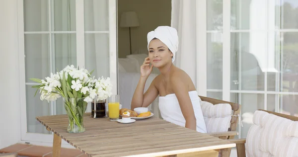 Femme enveloppée dans une serviette assise à la table — Photo