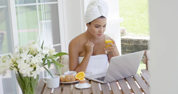 Donna in asciugamano con computer portatile che fa colazione — Foto Stock