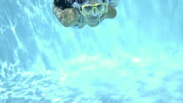 Woman in goggles swimming underwater — ストック動画