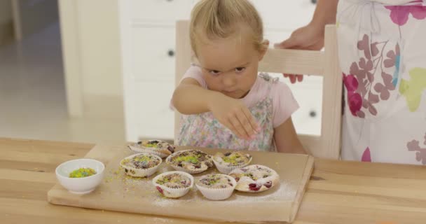 Kız yağmurlama Topingler çörek üzerinde — Stok video