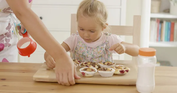 Kvinna att placera muffins framför barn — Stockfoto