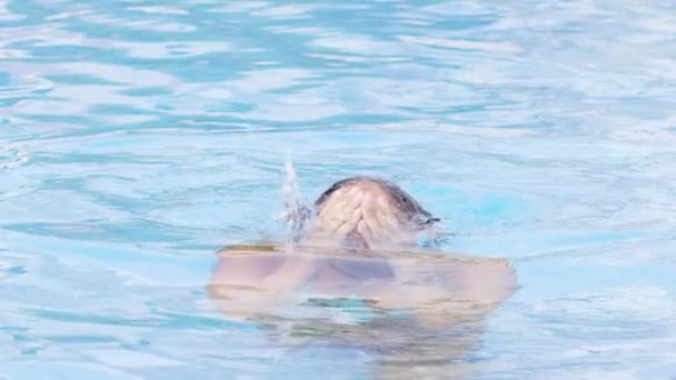 Mujer con bikini azul emerge de la piscina — Vídeos de Stock
