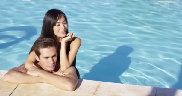 Woman hugs boyfriend in swimming pool — Stockvideo