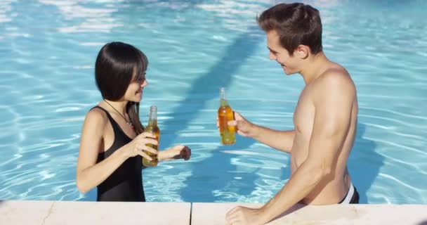 Handsome couple toasts in swimming pool — Stock Video