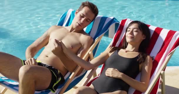 Young couple sunbathing in deck chairs — Stok video