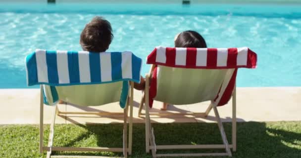 Couple relaxing in colorful deck chairs — Stock Video