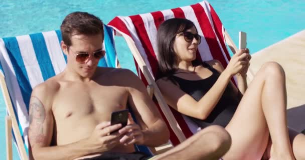 Casal usando telefones na piscina — Vídeo de Stock