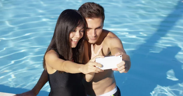 Woman in black swim suit takes photo — Stockfoto