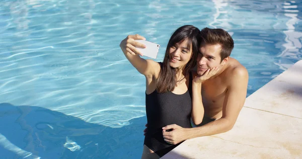 Pareja tomar fotos mientras está de pie en la piscina —  Fotos de Stock