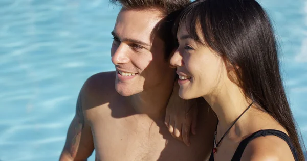 Casal sentado ao lado da piscina — Fotografia de Stock