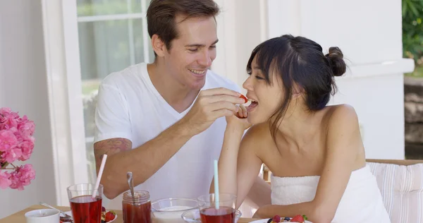 Mann füttert Frau beim Frühstück mit Obst — Stockfoto