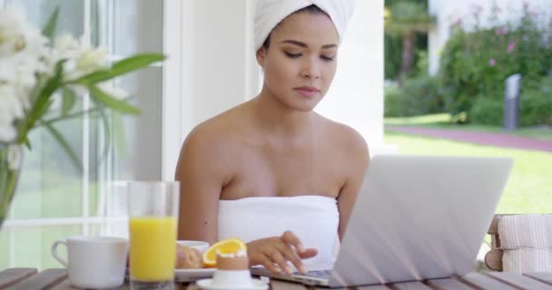 Femme utilisant un ordinateur portable tout en prenant le petit déjeuner — Video