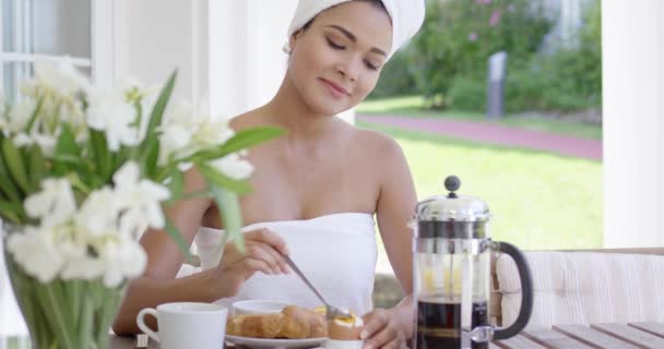 Woman eating breakfast on patio — ストック動画