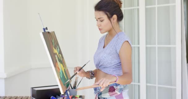 Vrouw kunstenaar schilderen op patio — Stockvideo