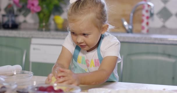 Маленькая девочка веселится, меся тесто. — стоковое видео