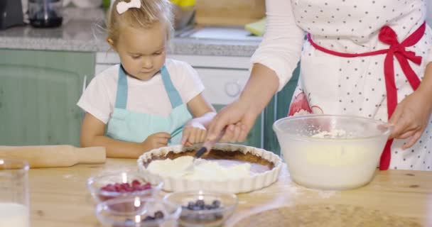 Hübsches kleines Mädchen lernt, einen Beerenkuchen zu backen — Stockvideo