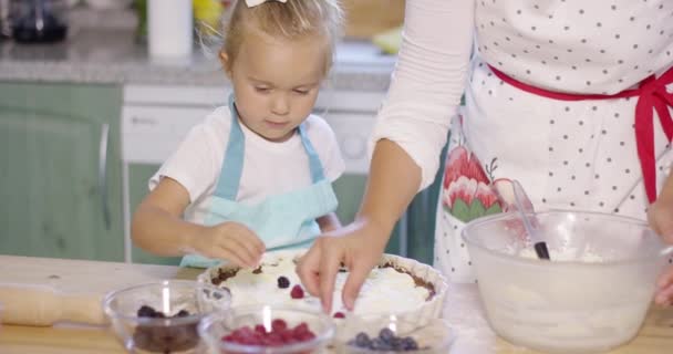 Liten flicka titta på bakning med förväntan — Stockvideo