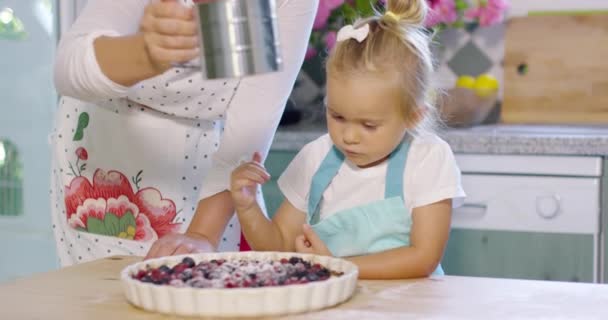 Adorable little girl engrossed in baking a pie — Stock Video
