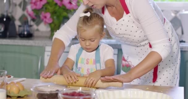 Mutter rollt mit einem kleinen Helfer Teig aus — Stockvideo