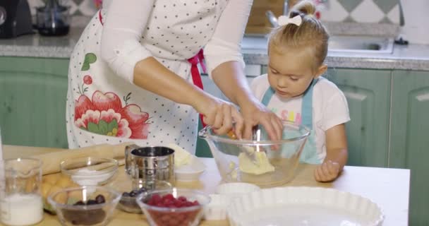 Moeder onderwijs haar kleine dochter om te bakken — Stockvideo