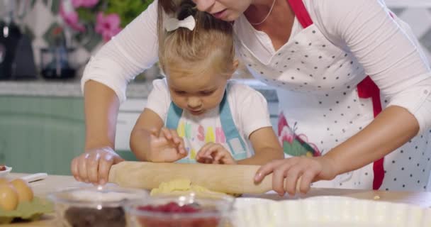 Madre desplegando pastelería con un poco de ayuda — Vídeos de Stock