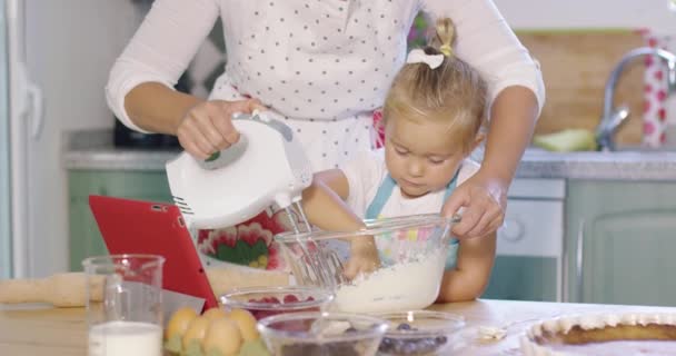 Niedliche kleine Küchenhelferin hilft ihrer Mutter — Stockvideo