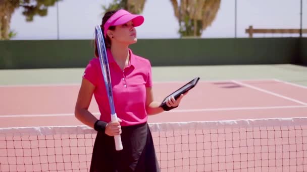 Frau überprüft Zeitplan für Tennisspiel — Stockvideo