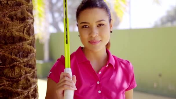 Woman with tennis racket beside palm tree — Stock Video